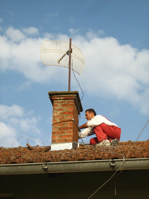 Brane Nikolić na krovu postavlja wifi antenu